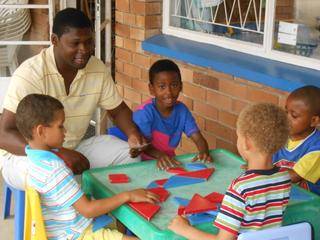 Daddy Bandile shows Milani and the other boys how to use instructions with the 3D-blocks.